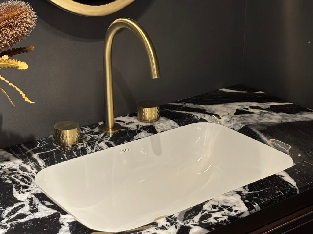 modern undermount bathroom sink with brass faucet